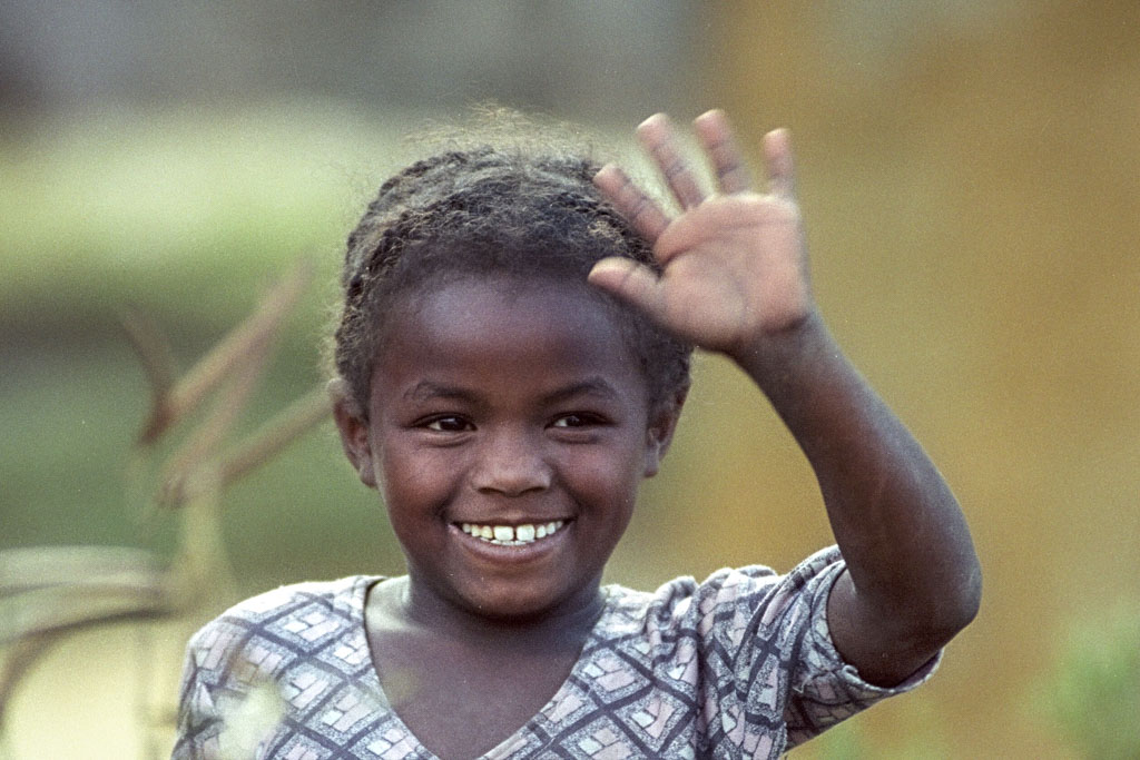 Winkendes Mädchen auf dem Wegesrand in Madagaskar Winkendes Mädchen auf dem Wegesrand in Madagaskar