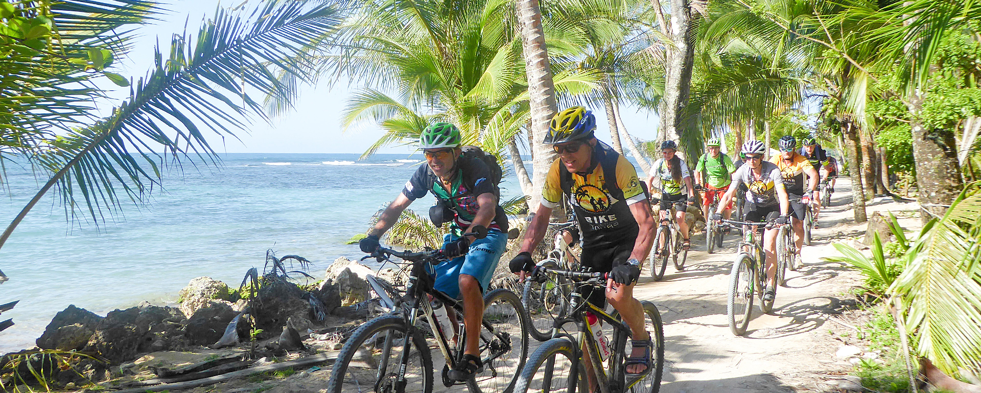 Biken am Strand entlang unter Palmen